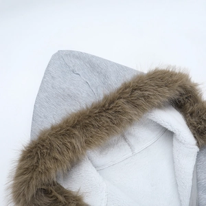 Détail d'un sweat à capuche gris avec col en fausse fourrure brune et doublure polaire