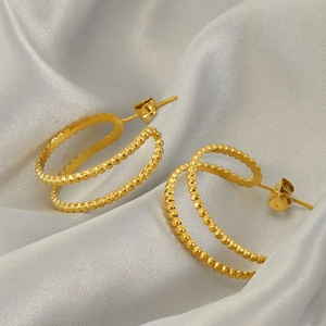 Golden double-hoop beaded earrings with a minimalist geometric hollow design on silk fabric