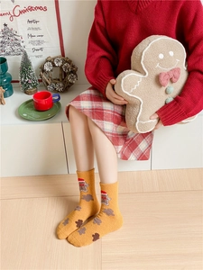 Detailed view of thick yellow coral fleece socks with gingerbread man embroidery