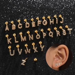 Close-up of gold-plated letter stud earrings with white zircons and screw ball back