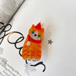 Cute acrylic orange tabby cat hair claw clip wearing a red Christmas hat and scarf