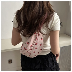 Detail showing pink corduroy crescent bag with sweet strawberry pattern and wide strap