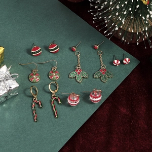 Detailed view of Christmas earring set with candy cane and festive motifs on red velvet