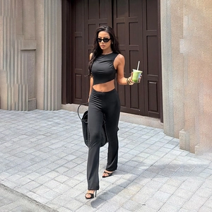 Ensemble chic noir deux pièces avec haut court sans manches et pantalon évasé taille haute