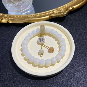 Weathered Bodhi bead bracelet with Xi character charm on a vintage tray display