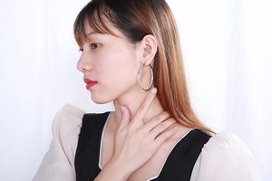 Detailed close-up of large silver stainless steel hoop earrings with sparkling cubic zirconia