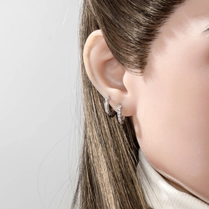 Minimalist geometric huggie earrings with cubic zirconia stones on female model