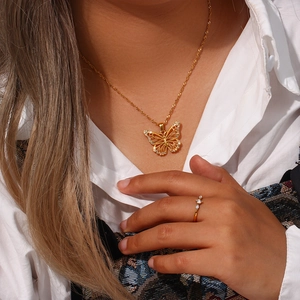 Detailed view of hollow gold butterfly pendant with crystals on a delicate chain