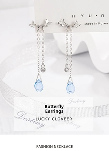 Detail view of silver butterfly tassel earrings with light blue drop pendant and chain