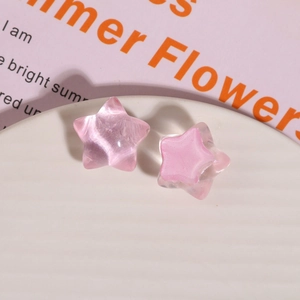 Macro detail of pink star-shaped resin charms with opal finish and clear core textures