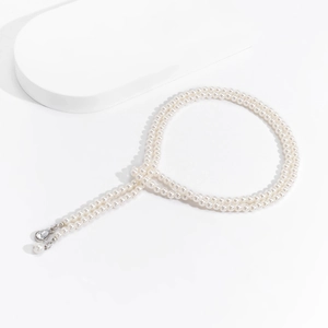 Detail of layered pearl necklace with heart pendant and water drop crystal charm