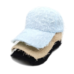 Detail of baseball caps showing layered fringe texture in blue, khaki, and black colors