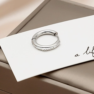 Silver circle hoop earring with sparkling zirconia inlays on a premium display box