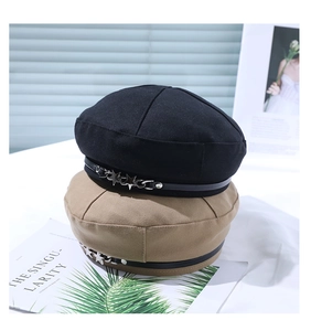 Detail of vintage beret hats with leather strap and silver star studs in black and khaki