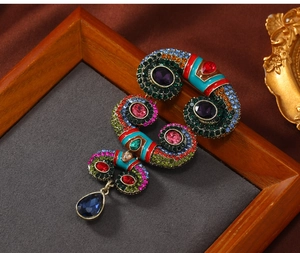 Close-up of vintage horn brooch with colorful rhinestones and pear-cut crystal drop