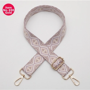 Detail of colorful geometric woven bag strap with golden metal swivel hooks and slider