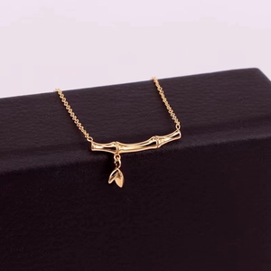 Elegant 18k gold bamboo joint necklace with delicate leaf pendants on black gift box