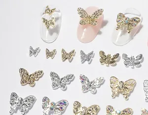 Detailed view of assorted metal butterfly nail charms with rhinestones and pearls