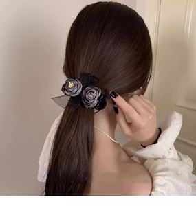 Rear view of model wearing grey fabric rose hair claw clip with black lace details