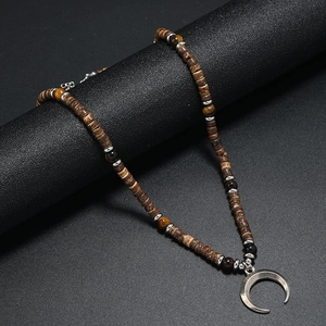 Detail of bohemian crescent moon pendant necklace with dark wood beads on a display stand