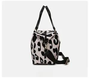 Side view of travel bag featuring cow print fabric, side zipper pocket and shoulder strap