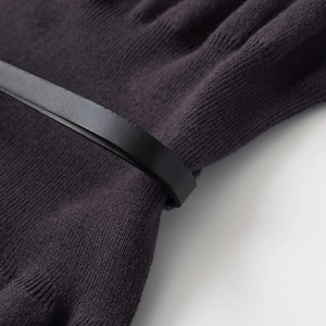 Close-up of deep purple knit dress featuring detailed texture and a black leather belt