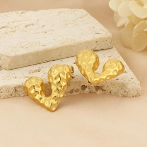 Detailed close-up of 18k gold-plated heart earrings with hammered texture on stone base
