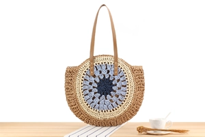 Detailed close-up of sunburst mandala pattern on circular woven paper rope beach bag