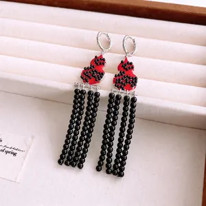Vintage Chinese style gourd earrings with red body and black beaded tassels in a display box