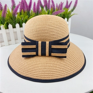 Detailed macro view of woven straw sun hat texture with navy ribbon and bow detail