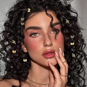 Gros plan de bijoux de cheveux dorés et de breloques couronne sur cheveux tressés