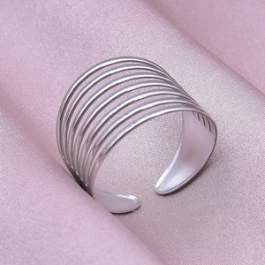 Macro view of minimalist multi-layer hollow silver steel ring on purple silk fabric
