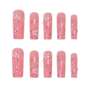 Pink press-on nails with floral 3D charms, pearls, and rhinestones in long square shape
