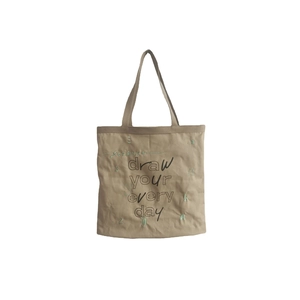 Minimalist beige canvas tote bag with graffiti lettering and green embroidery logo