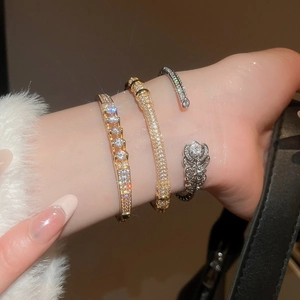 Detailed close-up of three sparkling gold and silver plated zircon bracelets on a wrist