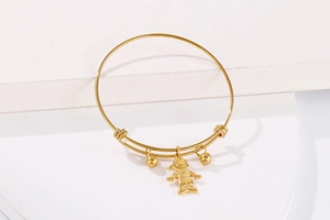Détail du bracelet en acier titane doré avec pendentif garçon sur escalier blanc
