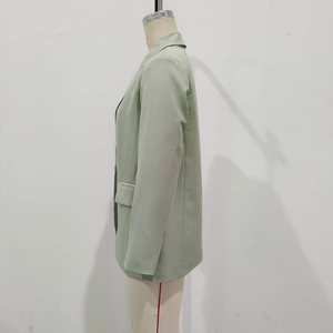 Detail view of the sage green blazer with notched lapels and side flap pockets