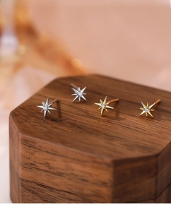 Macro shot of S999 sterling silver eight-pointed star stud earrings with zircon stones