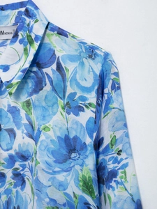 Close-up detail of blue floral print and collar texture on a long-sleeve women's shirt