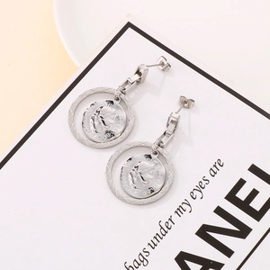 Detailed view of silver coin earrings featuring Elizabeth II relief and textured hoop