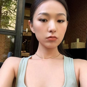 Minimalist gold chain necklace with half-diamond design worn by model in outdoor setting