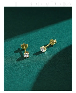 Detail of gold-plated S925 silver stud earrings with round moissanite in four-prong setting