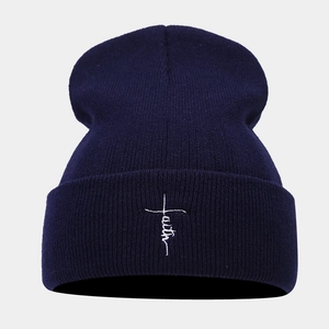 Detailed view of faith cross embroidery on navy blue ribbed knit beanie hat cuff