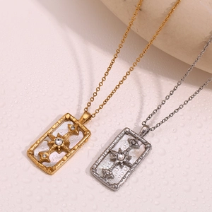Detail of gold and silver rectangular star pendants with crystals on a textured background