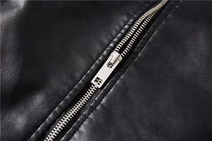 Detail shot of a silver metal zipper on premium black faux leather biker jacket