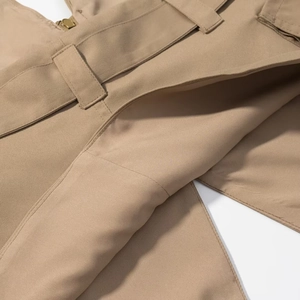 Dettaglio in tessuto twill kaki con cuciture di precisione sui passanti della cintura