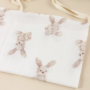 Macro detail of soft white muslin cotton baby organizer bag with brown bunny print