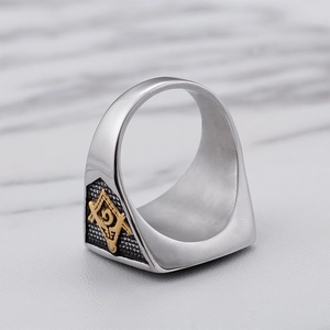Two-tone stainless steel Masonic ring with gold G-letter square and compass on marble