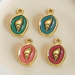 Macro shot of stainless steel ocean-themed pendants with shell relief and enamel finish