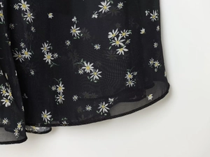 Dettaglio ravvicinato del tessuto chiffon floreale che mostra la trama e la cucitura